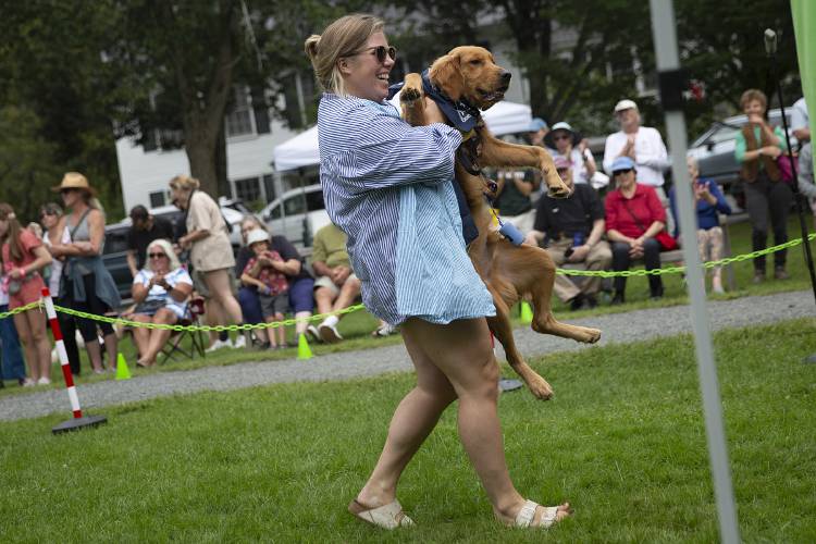 Katie Stiffler, of New York City, carries her 7-month-old golden retriever Chuck during Puppies and Pooches On Parade on the green in Woodstock, Vt., on Saturday, August 26, 2023. “He’s never met a stranger,” Stiffler said of her very friendly dog. (Valley News / Report For America - Alex Driehaus) Copyright Valley News. May not be reprinted or used online without permission. Send requests to permission@vnews.com.