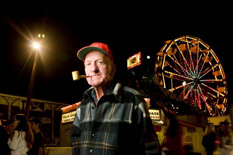 Bernard Blaine, of Windsor, Vt., stands in the midway at the Tunbridge World's Fair on Sept. 11, 2008, people-watching and smoking his favorite Prince Albert tobacco in one of the corn cob pipes he buys in bulk from a distributor in Hancock, Vt. Blaine said he has been coming to the fair for at least 14 years. He had always wanted to come for years before that, but was scared away by stories he heard about the rough crowd. 