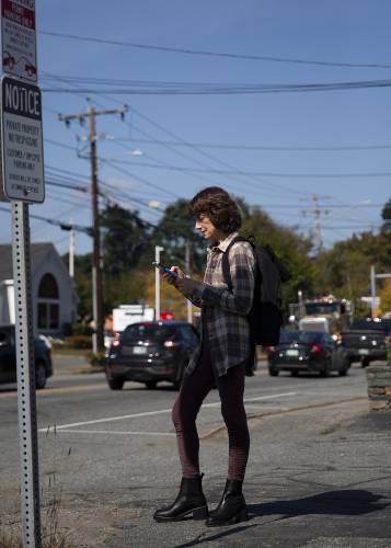 Victoria Somoff, of West Lebanon, N.H., waits for her bus at the Advance Transit bus stop in front of Kilton Library in West Lebanon on Monday, Oct. 2, 2023. The bus service’s newly expanded hours have offered flexibility to riders like Somoff, who said she no longer has to check the transit schedule when she stays late at work because she knows a bus will be available. “I don’t have to worry,” she said. (Valley News / Report For America - Alex Driehaus) Copyright Valley News. May not be reprinted or used online without permission. Send requests to permission@vnews.com.