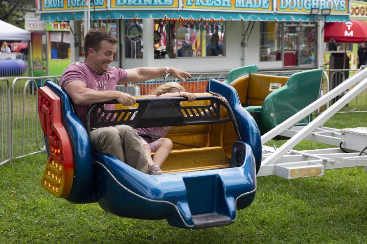 Eleanor Tietz, 6, of Hartford, Vt., holds on tight while she and her uncle Ronan Moyer, of Winooski, Vt., ride the Sizzler during the Norwich fair on the green in Norwich, Vt., on Saturday, August 12, 2023. (Valley News / Report For America - Alex Driehaus) Copyright Valley News. May not be reprinted or used online without permission. Send requests to permission@vnews.com.