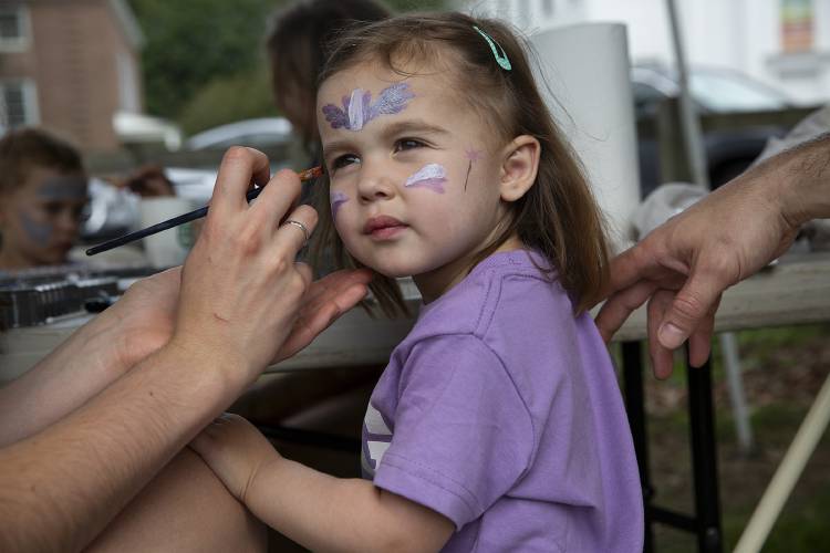 Nava Rolsma, 3, of Lebanon, N.H., has her face painted by Nina Sablan, 17, of Norwich, Vt., during the Norwich fair on the green in Norwich on Saturday, August 12, 2023. (Valley News / Report For America - Alex Driehaus) Copyright Valley News. May not be reprinted or used online without permission. Send requests to permission@vnews.com.
