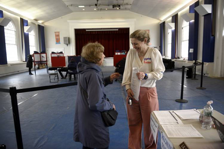 Norwich voter Pat Dickens laughs with Town Clerk Lily Trajman about her ballot during voting at Tracy Hall in Norwich, Vt., on Tuesday, March, 5, 2024, in Norwich, Vt. 