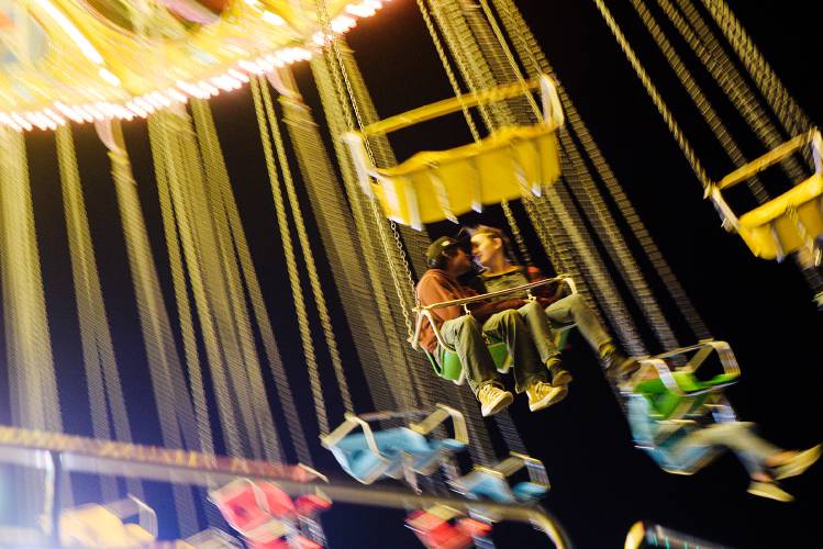 Xhangdee Moreno, 18, of Chelsea, left, shares a ride on the Swing Carousel with Natalie Murphy, 16, of Sharon, right, at the Tunbridge Fair in Tunbridge, Vt., on Thursday, Sept. 16, 2022. Murphy said her favorite part of the fair is Antique Hill, with its living history exhibits. 