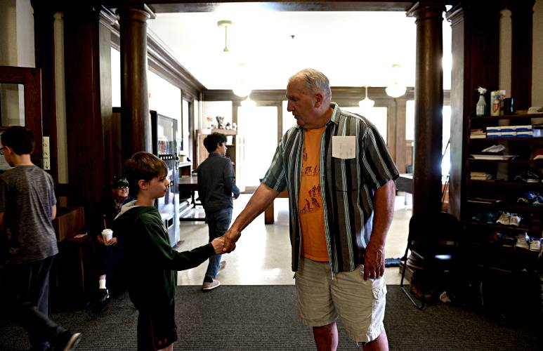 Jim Vanier, the longtime CCB director, thanks Cole Wetmore,10, of Lebanon, N.H., with a handshake on Thursday, May 30, 2019 at the Carter Community Building in Lebanon, N.H. (Valley News - Jennifer Hauck) Copyright Valley News. May not be reprinted or used online without permission. Send requests to permission@vnews.com.