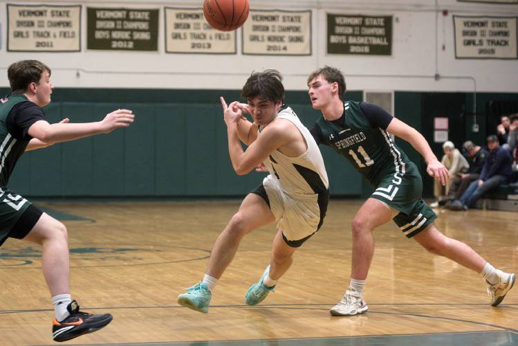 Luke Stocker, of Springfield, right, pops the ball away from Zach Martsolf-Tan, of Woodstock, middle, as he tries to make his way past Jacob Bennett, left, of Springfield, in Woodstock, Vt., on Monday, Jan. 29, 2024. Springfield won 50-41. (Valley News - James M. Patterson) Copyright Valley News. May not be reprinted or used online without permission. Send requests to permission@vnews.com.