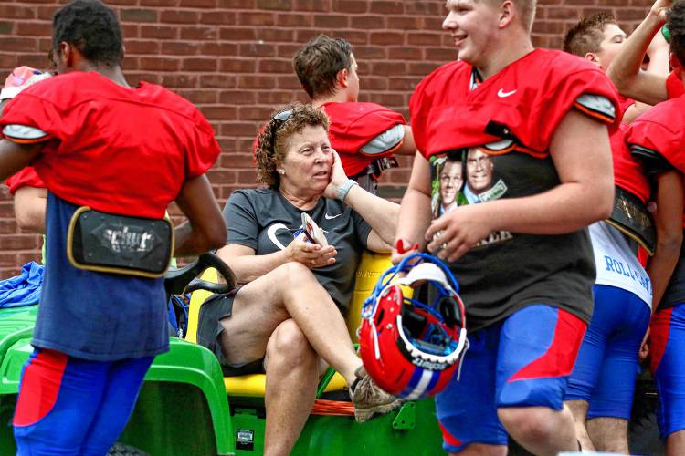 Jeni Frechette, one of Hartford High’s certified athletic trainers, is surrounded by hydrating football players during an August 16, 2023, practice in White River Junction, Vt. (Valley News - Tris Wykes) Copyright Valley News. May not be reprinted or used online without permission. Send requests to permission@vnews.com.