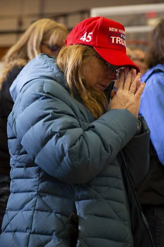 Thelma Poitras, of Woodsville, N.H., bows her head in prayer during the invocation at a campaign rally for former President Donald Trump at Stevens High School in Claremont, N.H., on Saturday, Nov. 11, 2023. (Valley News / Report For America - Alex Driehaus) Copyright Valley News. May not be reprinted or used online without permission. Send requests to permission@vnews.com.
