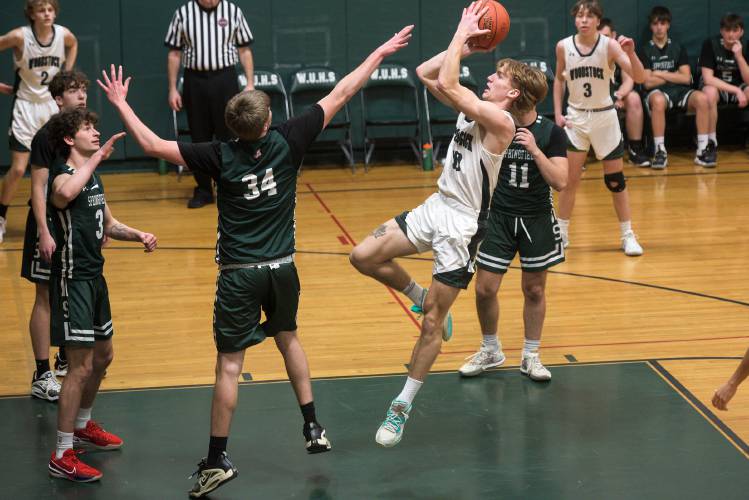 Ezra Lockhart fades back for a shot over Nick Wiese, of Springfield in Woodstock, Vt., on Monday, Jan. 29, 2024. Springfield won 50-41. (Valley News - James M. Patterson) Copyright Valley News. May not be reprinted or used online without permission. Send requests to permission@vnews.com.