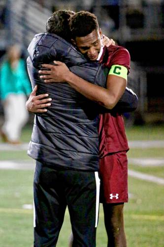 Hanover High's Ryder Hayes, right, embraces associate head coach Sam Farnham after their team's 4-0 loss to Bedford in the NHIAA Division I title game on Nov. 3, 2023, at Stellos Stadium in Nashua, N.H. (Valley News - Tris Wykes) Copyright Valley News. May not be reprinted or used online without permission. Send requests to permission@vnews.com.