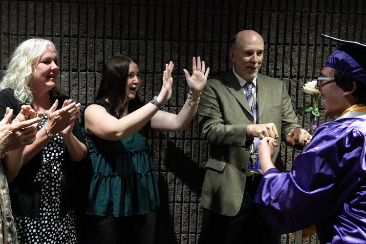 Graduating senior Sam Steinberg, right, gets a cheer from guidance counselors Stephanie Cooney, left, Ayla Steere, middle, and Eric Ramage during the procession to Mascoma High School's 59th commencement in West Canaan, N.H., on Friday, June 16, 2023. Steinberg was one of 73 seniors to receive their diplomas during the ceremony. (Valley News - James M. Patterson) Copyright Valley News. May not be reprinted or used online without permission. Send requests to permission@vnews.com.