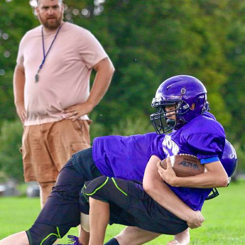 Oxbow High assistant coach Nick Ditcheos watches as ball carrier Tanner Bernier is tackled during an Aug. 18, 2023, practice in Bradford, Vt. (Valley News - Tris Wykes) Copyright Valley News. May not be reprinted or used online without permission. Send requests to permission@vnews.com.