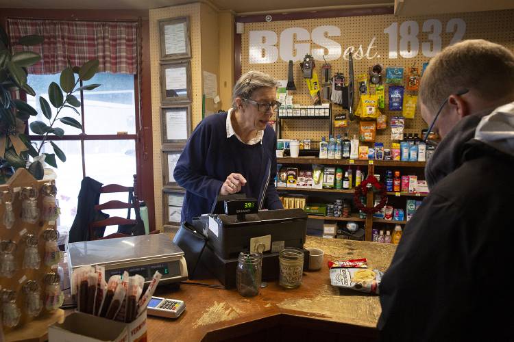 Cashier Gayle Rountree, left, rings up Carter Wilson, of Woodstock, Vt., at Barnard General Store in Barnard, Vt., on Monday, Dec. 18, 2023. Nearly 600 Barnard residents lost power on Monday morning and Rountree said several people showed up at the store, which has a generator, to connect to the internet or access services for neighbors in need. “That’s what these kinds of places are for,” Rountree said of the store. “This is a community resource.” (Valley News / Report For America - Alex Driehaus) Copyright Valley News. May not be reprinted or used online without permission. Send requests to permission@vnews.com.