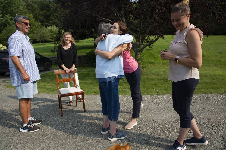 Antonina Reznichenko, center right, hugs her neighbor Betsey David, while spending time with Darwin and Linda Eton, left, and Iryna Burtolik, right, in Hartland, Vt., on Wednesday, August 9, 2023. The Etons sponsored Reznichenko and Burtolik along with their children after connecting on a website for Ukrainian asylum seekers, and the families have been living in the Etons’ guest house since arriving in the United States in February. (Valley News / Report For America - Alex Driehaus) Copyright Valley News. May not be reprinted or used online without permission. Send requests to permission@vnews.com.