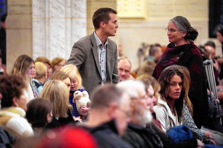 Rep. Jared Golden, D-Maine, speaks with a woman at a vigil for the victims of the mass shootings several days earlier, at the Basilica of Saints Peter and Paul, Sunday, Oct. 29, 2023, in Lewiston, Maine. (AP Photo/Robert F. Bukaty)