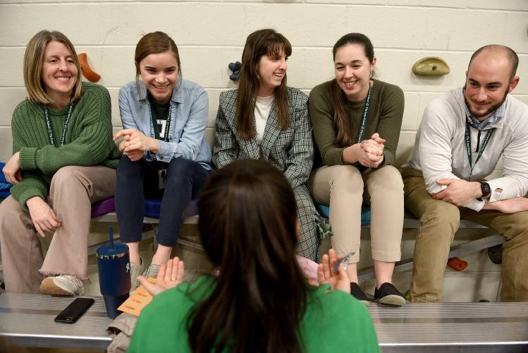 Lyme School teachers Amanda Burns, left, Emily Cushman, Shannon O'Leary, Tori Thayer, Tyler Rooke and school counselor Rachel Stanton, in foreground, pass the time during voting at Lyme’s school meeting on Thursday, March 8, 2024, in Lyme, N.H. Floor discussions had stopped for voters to cast their ballots. The group posed a question to one another: “If you were a potato, what kind of potato would you be?