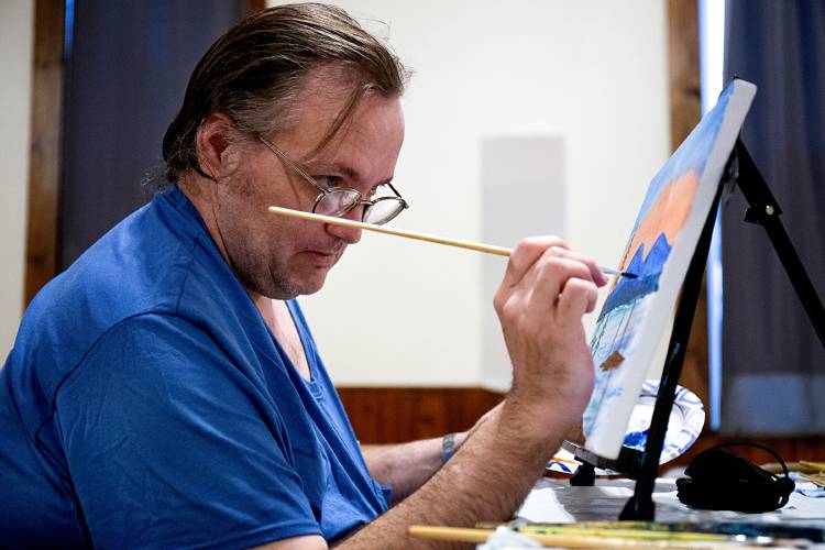 Michael Tatham, of Enfield, N.H., brushes details into his painting during a Bob Ross Paint Night session at the Seven Stars Arts Center in Sharon on Sept. 8, 2023. Tatham said he had taken a Bob Ross painting class years ago at the Ames Department Store in West Lebanon, N.H. (Valley News - Geoff Hansen) Copyright Valley News. May not be reprinted or used online without permission. Send requests to permission@vnews.com.