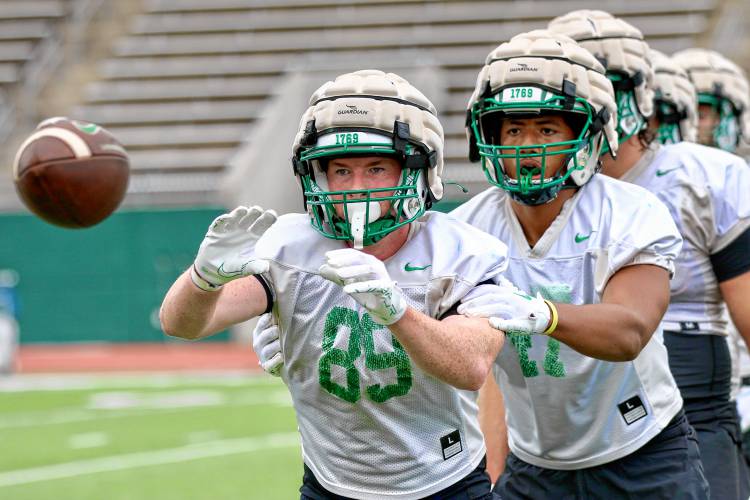 Dartmouth College tight end Sean Ward (89) concentrates on an incoming pass while teammate Tysire Williams attempts to distract him on Aug. 19, 2023, at Memorial Field in Hanover, N.H. The Big Green held its first preseason practice. (Valley News - Tris Wykes) Copyright Valley News. May not be reprinted or used online without permission. Send requests to permission@vnews.com.