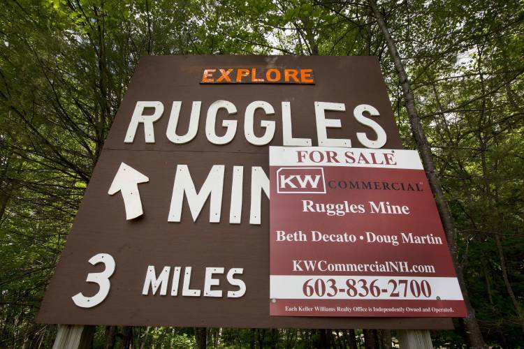 In this photo taken Wednesday June 8, 2016 one of many signs along New Hampshire's roads for Ruggles Mine is seen in Grafton, N.H. The mine, which has been a tourist attraction for 50 years, is now for sale. (AP Photo/Jim Cole)