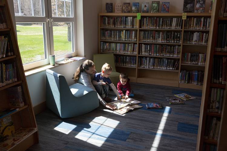 From left, Jenny Ramsey, of Meriden, N.H., reads a book with her son Andrew Ramsey, 4, and his friend Rowen Griffin, 3, of Plainfield, N.H., at the Meriden Library on Friday, April 21, 2023. Ramsey said her family had missed the community space since the old library building was demolished in October 2021. “What we really like about the Meriden Library is that we can walk from our house,” she said. (Valley News / Report For America - Alex Driehaus) Copyright Valley News. May not be reprinted or used online without permission. Send requests to permission@vnews.com.