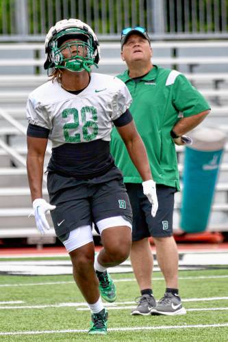Dartmouth College's Chris Roper (28) and running backs coach Danny O'Dea watch a kickoff descend during the Big Green's opening preseason practice on Aug. 19, 2023, on Memorial Field in Hanover, N.H. (Valley News - Tris Wykes) Copyright Valley News. May not be reprinted or used online without permission. Send requests to permission@vnews.com.