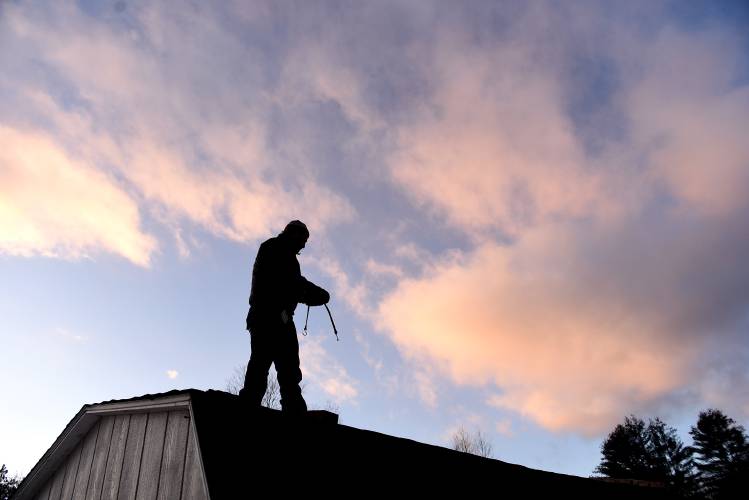 On a windy raw day, Radley Herold, of Thetford, Vt., removes a tarp from his shed roof on Wednesday, Feb. 14, 2024. Herold was trying to contain a leak in the roof, but decided to do it on a calmer day. He is storing cedar in the shed to make a canoe and wanted to make sure the wood was kept dry. Needing a project during the COVID-19 pandemic, Herold made his first cedar canoe. learning the craft from books. (Valley News - Jennifer Hauck) Copyright Valley News. May not be reprinted or used online without permission. Send requests to permission@vnews.com.