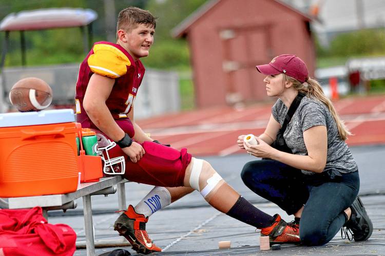 Lebanon High's Jonathan Eylander is treated by certified athletic trainer Amanda Martin during the Raiders' defeat of Mount Anthony on Sept. 11, 2023, on Henry Emerson Field in Lebanon, N.H. (Valley News - Tris Wykes) Copyright Valley News. May not be reprinted or used online without permission. Send requests to permission@vnews.com.