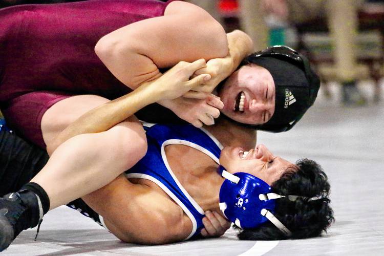 Lebanon High's Abigail Stone and Manchester West's Samuel Cruz grimace while wrestling at 120 pounds on Dec. 30, 2023, in Lebanon, N.H. Stone won by pin, avenging a loss to Cruz earlier in the day at a 17-team tournament hosted by the Raiders. (Valley News - Tris Wykes) Copyright Valley News. May not be reprinted or used online without permission. Send requests to permission@vnews.com.