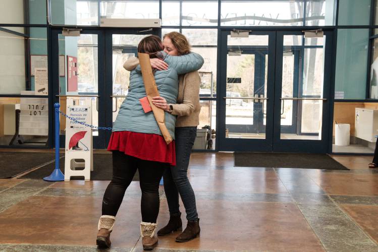 As part of a project to bring fellow widows and widowers roses and cards on Valentine's Day, Krista Patronick, of Hanover, left, gets a hug from Jennifer Baxter, right, after making a delivery to her at the Upper Valley Aquatic Center where she works in White River Junction, Vt., on Wednesday, Feb. 14, 2024. Baxter lost her husband Richard Kozlowski in January. 
