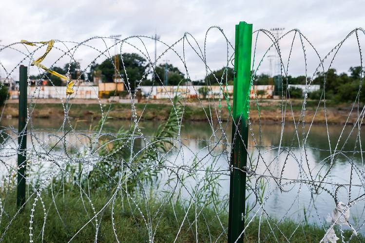 Barbed wire stretches along the Rio Grande on the United States side of the border to prevent the passage of undocumented migrants in Eagle Pass on Thursday, June 2, 2022. (Lola Gomez/Dallas Morning News/TNS)