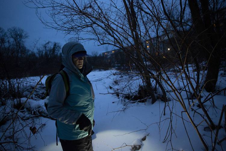 Volunteer Jeanette Hutchins, of West Lebanon, N.H., participates in the annual Point-in-Time Count, searching for encampments on the bank of the Mascoma River near Canillas Community Garden in Lebanon, N.H., on Wednesday, Jan. 24, 2024. A team of Listen Community Services employees and volunteers fanned out across the city on Wednesday evening and Thursday morning to find and interview individuals experiencing homelessness. (Valley News / Report For America - Alex Driehaus) Copyright Valley News. May not be reprinted or used online without permission. Send requests to permission@vnews.com.