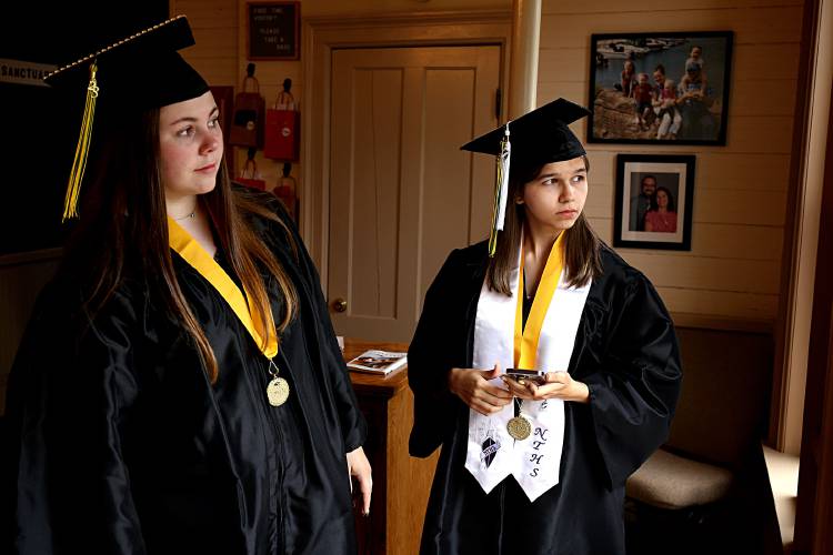 Tarin Jones, left, and Natalie Kelley, both of South Royalton, Vt., watch friends and family arrive onto the town green as the White River Valley High School graduates get ready in the Red Door Church across the street in South Royalton, Vt., on June 17, 2023. (Valley News - Geoff Hansen) Copyright Valley News. May not be reprinted or used online without permission. Send requests to permission@vnews.com.