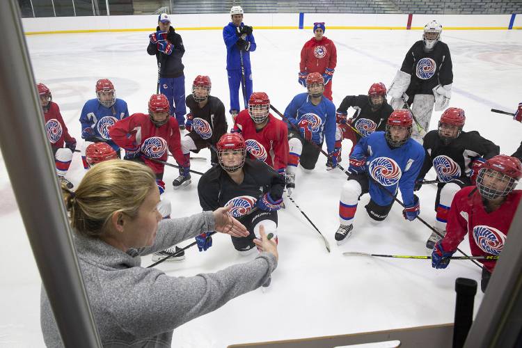 Hartford girls hockey head coach Kylie Young, left, explains a drill to her players during a practice at Barwood Arena in White River Junction, Vt., on Thursday, Nov. 30, 2023. The team, which lost to Middlebury in the quarterfinal round of VPA Division II girls hockey playoffs in February, has nine returning players and three who are brand new to the sport. Young said she expects this season’s team to be tight-knit, but with their wide array of skills they will have to work hard for their wins. (Valley News / Report For America - Alex Driehaus) Copyright Valley News. May not be reprinted or used online without permission. Send requests to permission@vnews.com.
