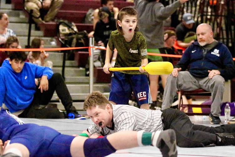 Will Strohbridge, a fifth-grade Lebanon Middle School student and wrestler, counts down the final seconds of a wrestling period while wielding a padded stick with which he will poke referee Eric Campbell to alert him that time has expired. 